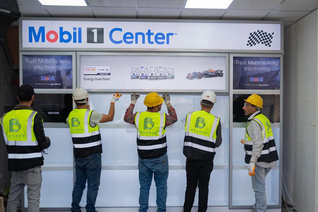 Beyond crew installing a Mobil 1 Center display